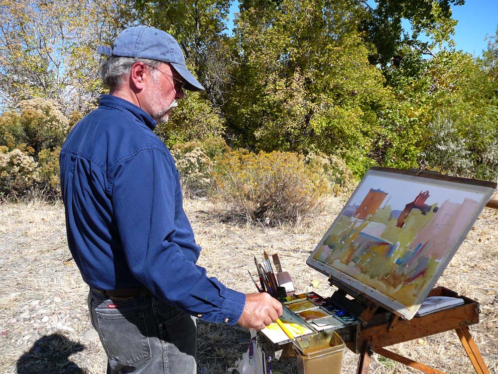 Frank LaLumia painting outside with trees and bushes in the background