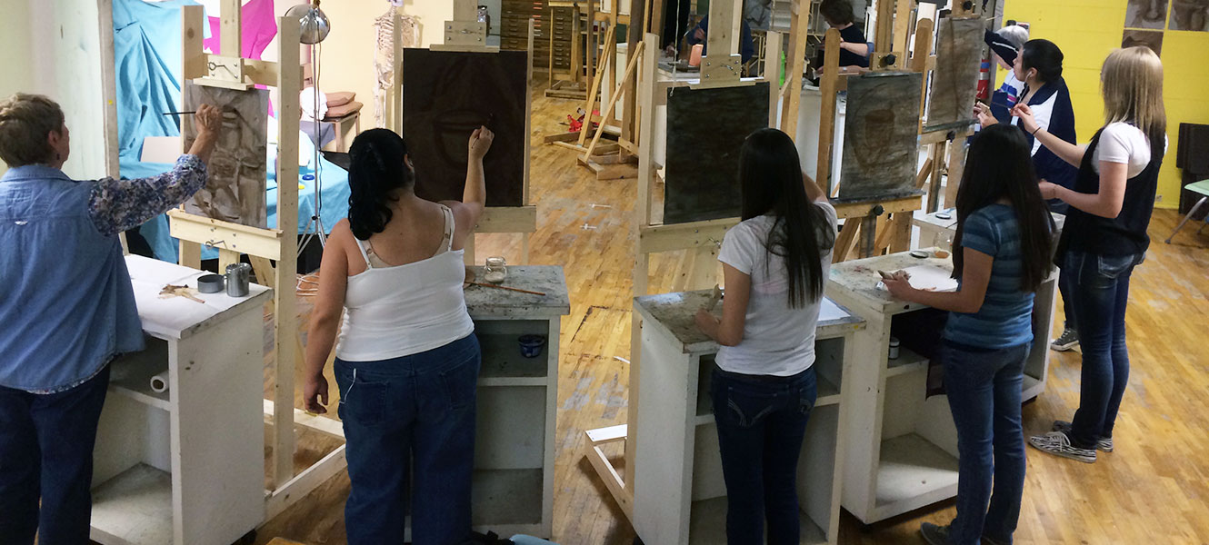 Students creating art on easels