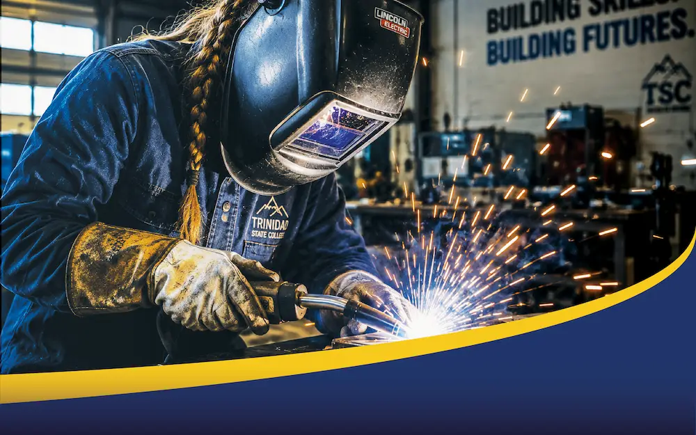 Trinidad State student welding with welding hood and gloves.