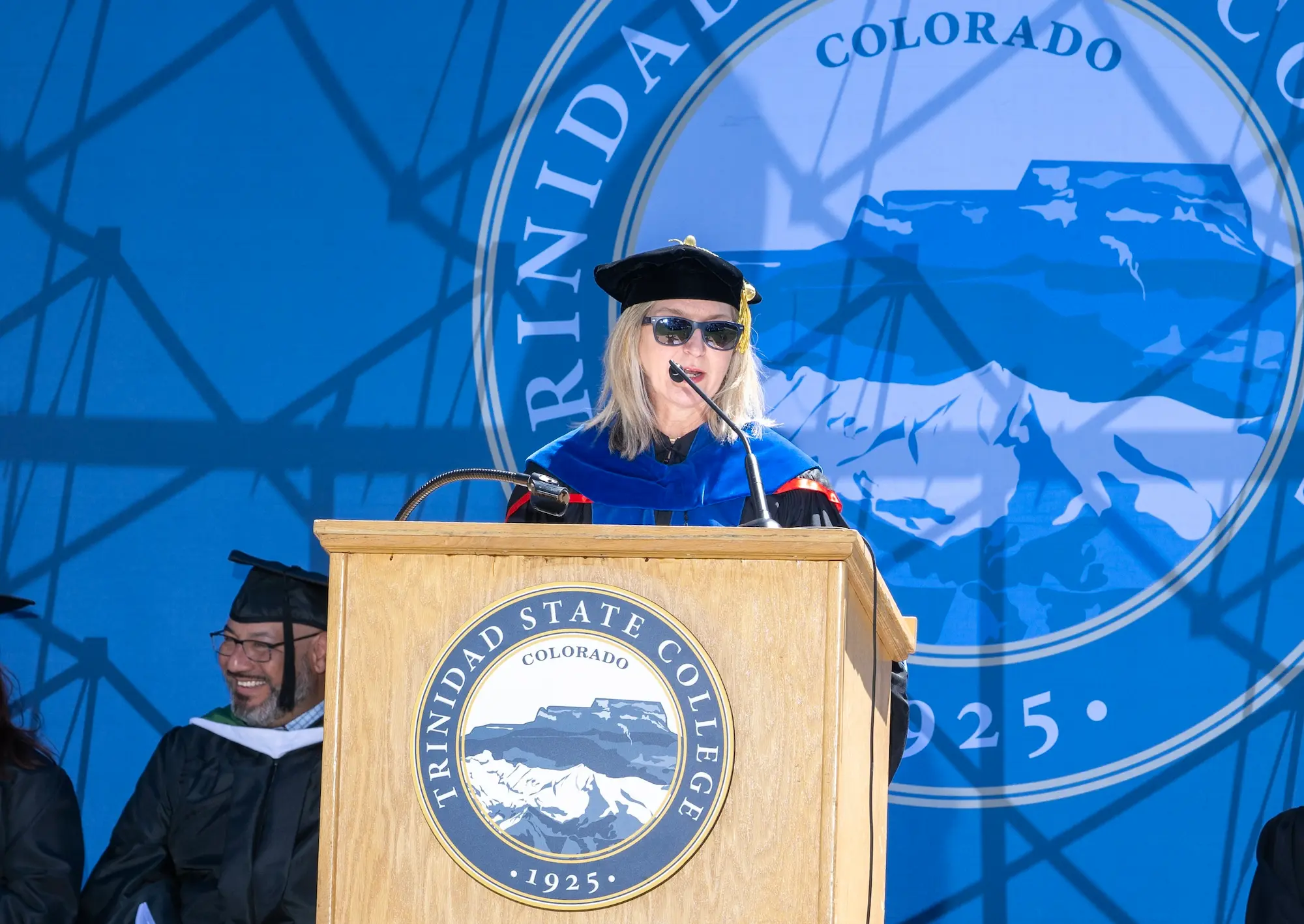 TSC president giving speech in cap and gown