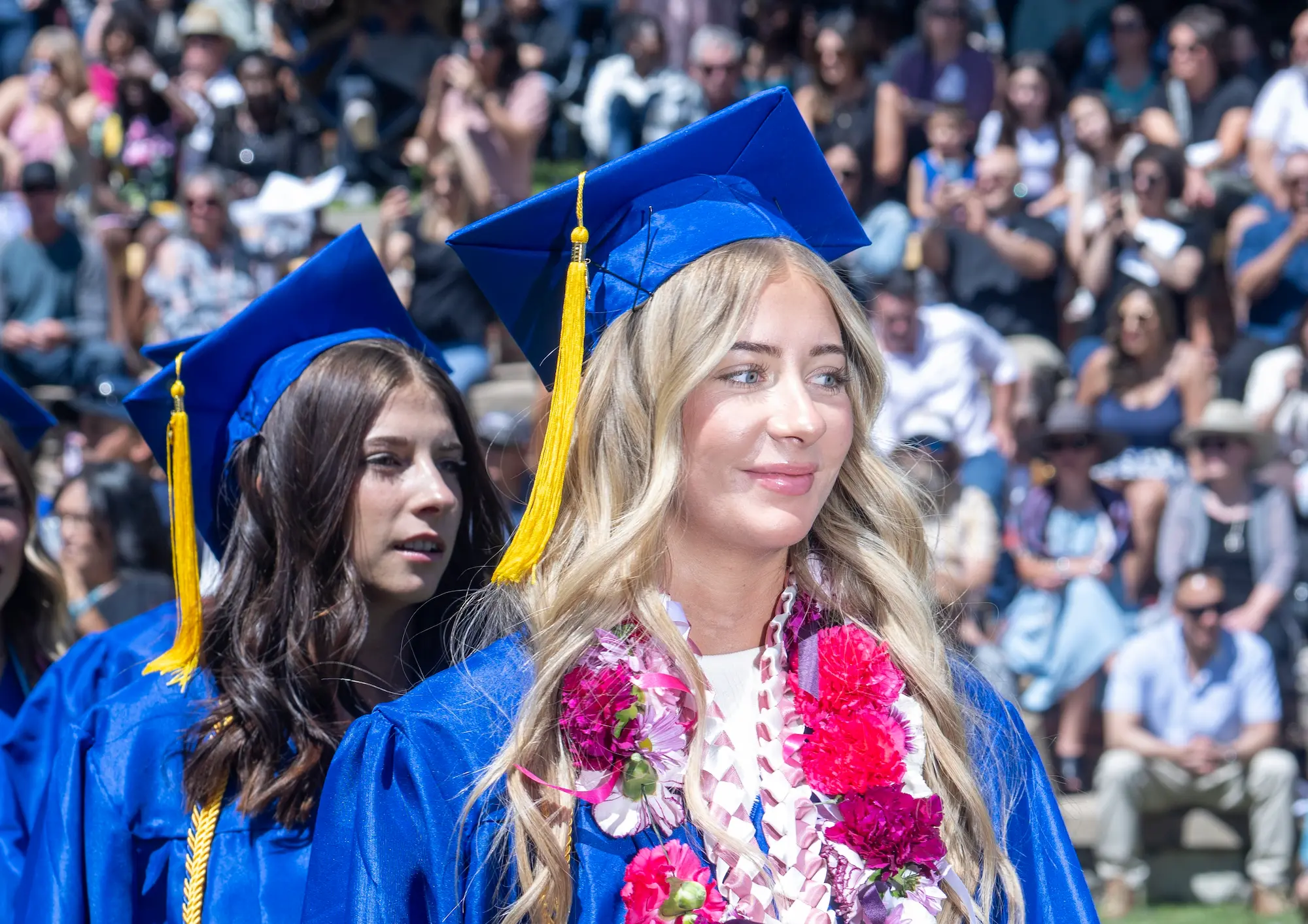 Student in blue cap and gown celebrating a scholarship award