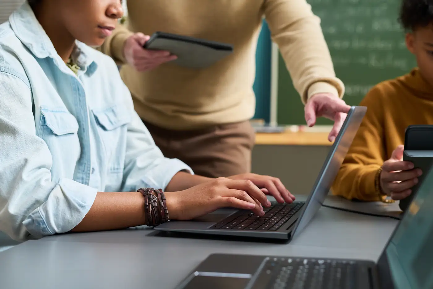 Teacher pointing at student's laptop
