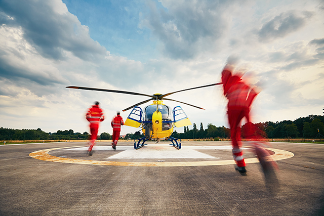 Paramedics running towards a helicopter image