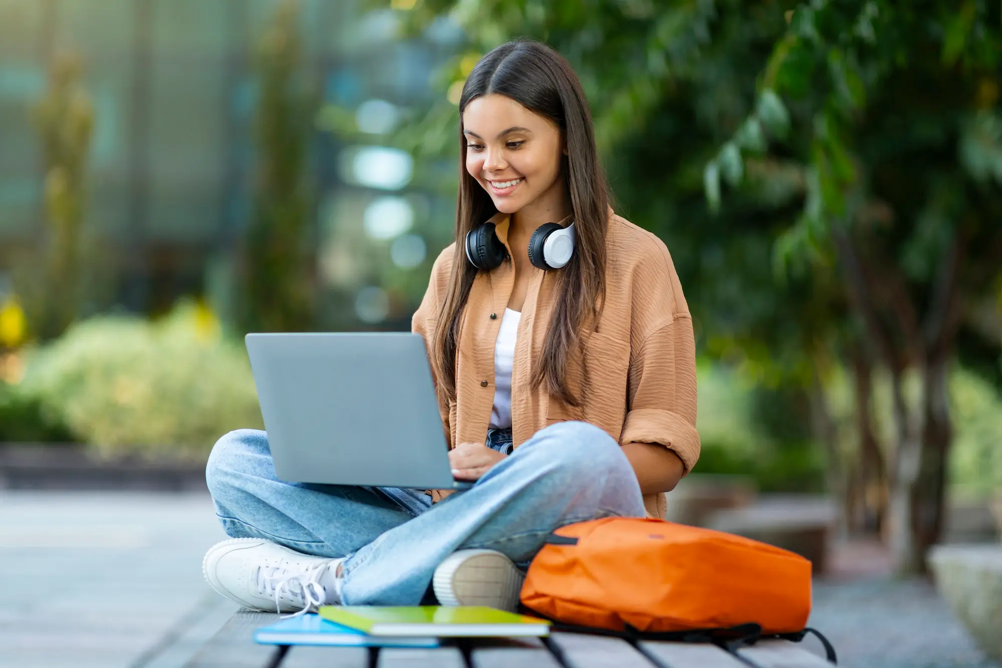 Smiling student registering for classes on laptop