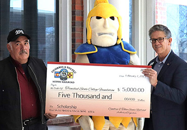 Scott Gibbs, the president of the Cumbres & Toltec Scenic Railroad presents scholarship check to James Kynoe, VP of the TSC Valley Campus